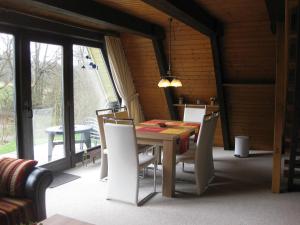 a dining room with a wooden table and chairs at Type Winnetou in Ronshausen