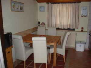 einen Esstisch mit weißen Stühlen und einem Holztisch in der Unterkunft Type Robinson in Ronshausen