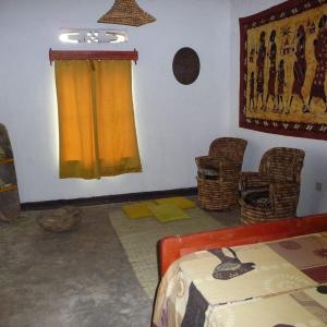 una camera con un letto e sedie e una finestra di NENA HOUSE a Rusatira