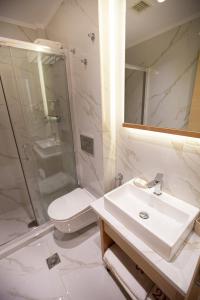 a bathroom with a sink and a shower and a toilet at No21 Luxury Suites in Thessaloniki