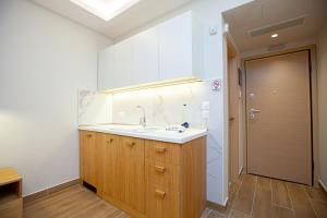 a kitchen with a sink and a wooden cabinet at No21 Luxury Suites in Thessaloniki