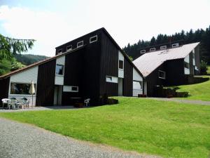 a black barn with a grassy field in front of it at Holiday park- Biberbau in Schmallenberg