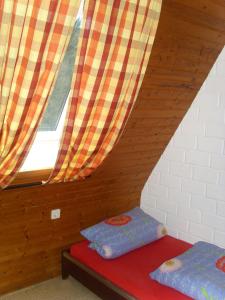 a attic room with two beds and a window at Typ Dachsbau in Schmallenberg
