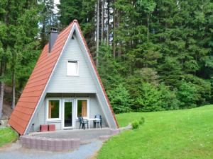 a small house with a red roof in a field at Typ Murmeltier in Schmallenberg