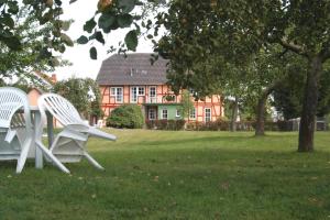 two white chairs sitting in the grass in front of a house at Ferienwohnungen Haus Froschkönig in Hannoversch Münden