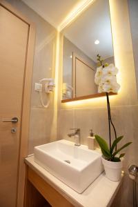 a bathroom with a white sink and a mirror at No21 Luxury Suites in Thessaloniki