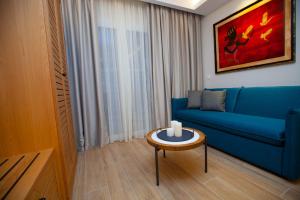 a living room with a blue couch and a table at No21 Luxury Suites in Thessaloniki