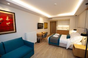 a hotel room with a bed and a blue couch at No21 Luxury Suites in Thessaloniki