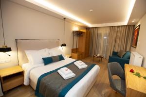 a hotel room with a bed and a chair at No21 Luxury Suites in Thessaloniki