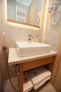 a bathroom with a white sink and a mirror at No21 Luxury Suites in Thessaloniki