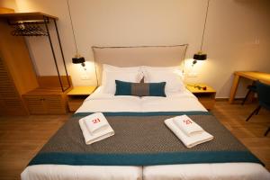 a bedroom with a large bed with two pillows on it at No21 Luxury Suites in Thessaloniki