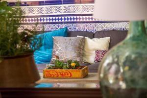 un divano con cuscini e un tavolo con una pianta di Aminta Home a Las Palmas de Gran Canaria