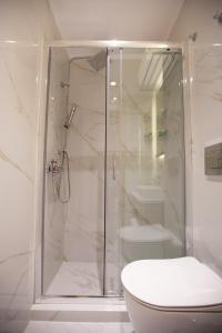 a bathroom with a shower with a toilet and a sink at No21 Luxury Suites in Thessaloniki