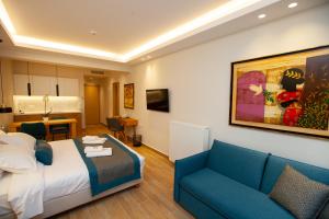 a hotel room with a bed and a blue couch at No21 Luxury Suites in Thessaloniki