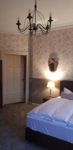 a bedroom with a bed and a chandelier and a door at Schlossgut Gorow in Satow