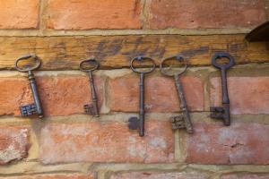 a group of old keys hanging on a brick wall at The Old House Guest House in Salisbury