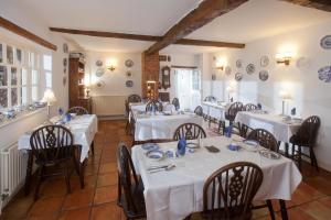 una sala da pranzo con tavoli e sedie bianchi di The Old House Guest House a Salisbury