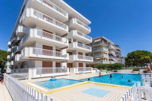 un hotel con piscina frente a un edificio en Residence Nautilus, en Lido di Jesolo