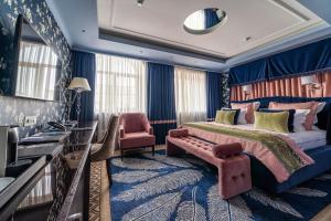 a bedroom with a king sized bed and a chair at Boutique Hotel Albora in Saint Petersburg
