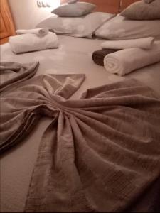 uma cama com lençóis brancos e toalhas em Apartment Marik em Jelsa