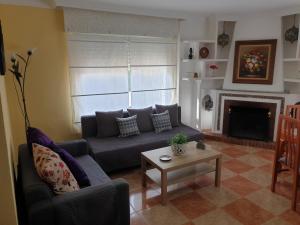uma sala de estar com um sofá e uma lareira em Casa Juan em Málaga