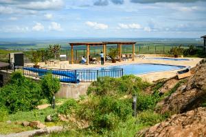 a swimming pool with a pavilion next to a mountain at Saab Royale Resort in Kajiado
