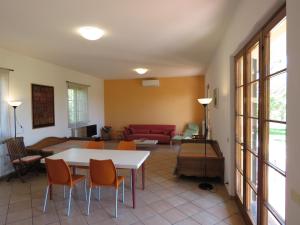 sala de estar con sofá, mesa y sillas en Ca' del Sale - Agriturismo con piscina e campo da tennis vicinanze Cinque Terre, en Ameglia