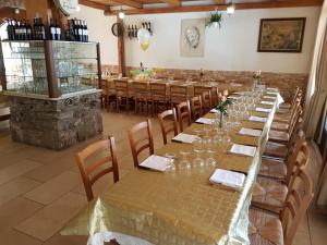 una fila di tavoli in una stanza con bottiglie di vino di B&B Antica Trattoria a San Giovanni Rotondo