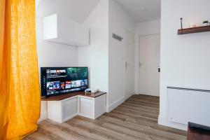 a living room with a flat screen tv on a wall at Studio Méan near Airbus and Chantiers Atlantique - wifi - parking in Saint-Nazaire