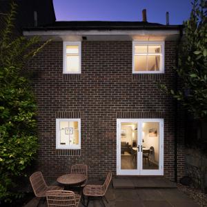 a brick house with a patio and a table and chairs at Central Portland Street with Free Parking in Brighton & Hove
