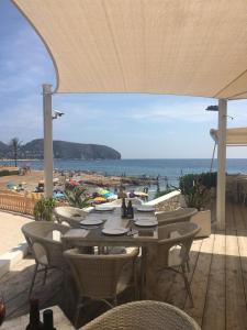 ein Tisch und Stühle mit Blick auf den Strand in der Unterkunft Sun Rise in Moraira