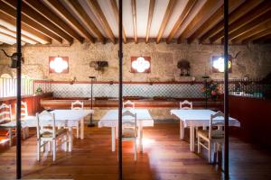 uma sala de jantar com mesas brancas e cadeiras brancas em Paço de S.Cipriano em Guimarães