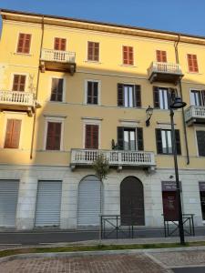 een geel gebouw met twee balkons in een straat bij Appartamento LE DUE ROCCHE in Arona