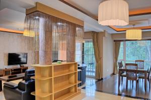 a living room with a couch and a dining room at Clarence House Nairobi in Nairobi