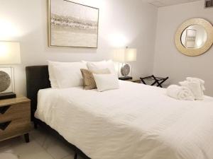 um quarto com uma grande cama branca e um espelho em 7 BR- Sleeps 15! Famous Lakefront Amazing Property! em Nova Orleães