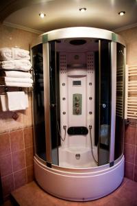 a small shower in a bathroom with towels at Knaus Apartments in Chernivtsi