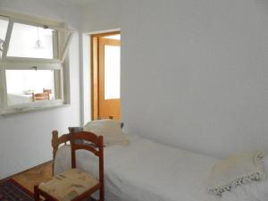 Un dormitorio con una cama y una ventana y una silla. en Villa Hortenzia, en Dubrovnik