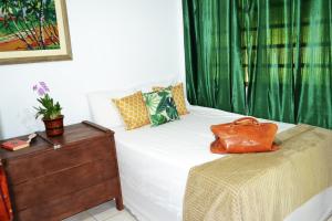 a bedroom with a bed with a brown purse on it at Casa de Temporada em Bonito-MS in Bonito