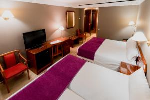 a hotel room with two beds and a television at Tulip Inn Andorra Delfos in Andorra la Vella
