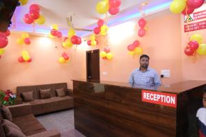 a man standing at a reception counter with balloons at HOTEL YOG TAPOVAN- Rafting Available in Rishīkesh