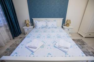 ein Schlafzimmer mit einem großen Bett mit zwei Nachttischen in der Unterkunft EGO Deluxe Apartment - central location in Sibiu