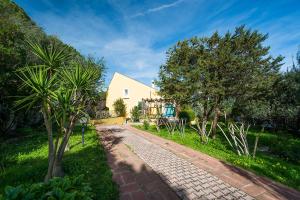 a cobblestone road in front of a house at Villa Alba - Appartamenti a 75 m dal mare in Cala Liberotto