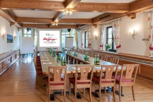 阿特湖畔努斯多夫Hotel & Restaurant Ragginger Attersee的一间有长桌和椅子的大餐厅