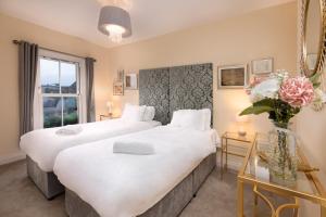 Dos camas en una habitación de hotel con un jarrón de flores en Caboose en Salisbury