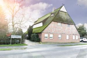 a large red brick building with a green roof at Ferienwohnung Mila in Grevenkop