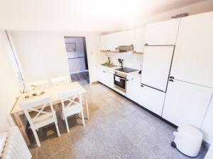 a kitchen with a table and a white refrigerator at Ferienwohnung Mila in Grevenkop