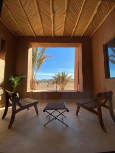 a room with two tables and a large window at Kasbah Tamsna in Ouarzazate