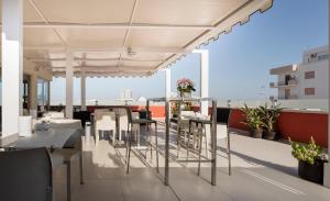 a balcony with tables and chairs on a building at Hotel 33 Baroni in Gallipoli