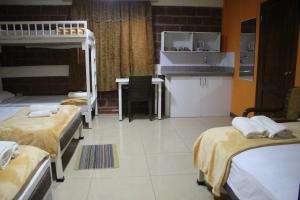 a room with three bunk beds and a kitchen at Sun Place in Las Tunas