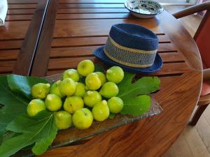 a bunch of grapes on a table with a hat at Gîte L'Appart de Case Vanille in Sari Solenzara